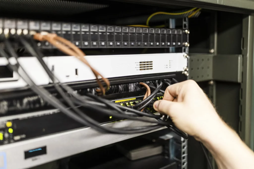 Nahaufnahme einer Hand, die ein Netzwerkkabel in einen Anschluss steckt