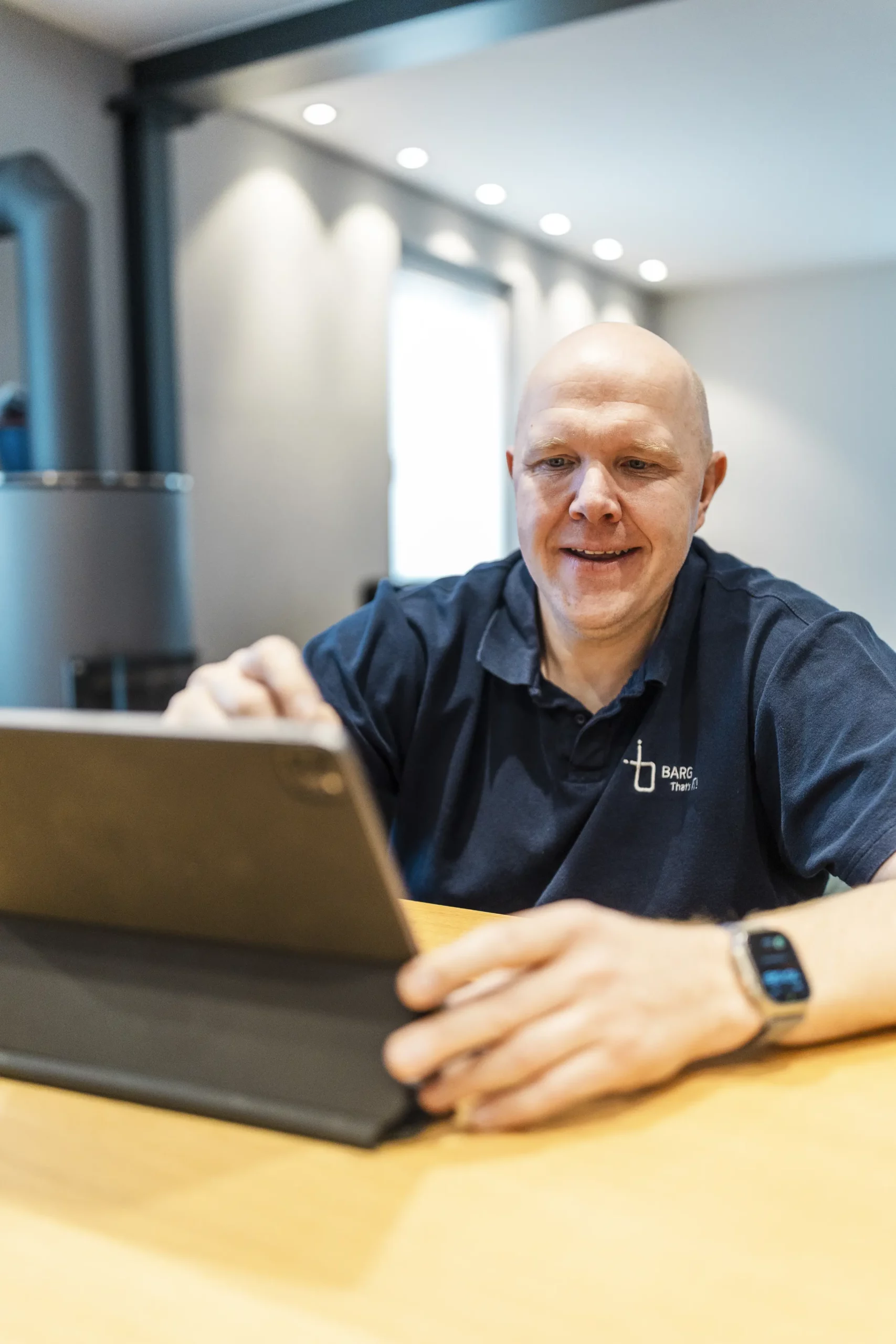 Mann bedient Tablet und lächelt leicht