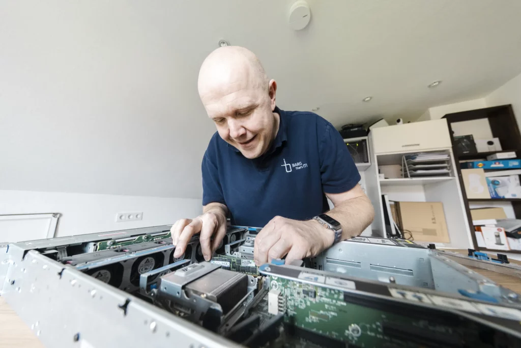 Mann öffnet Computergehäuse und arbeitet an Bauteilen im Inneren