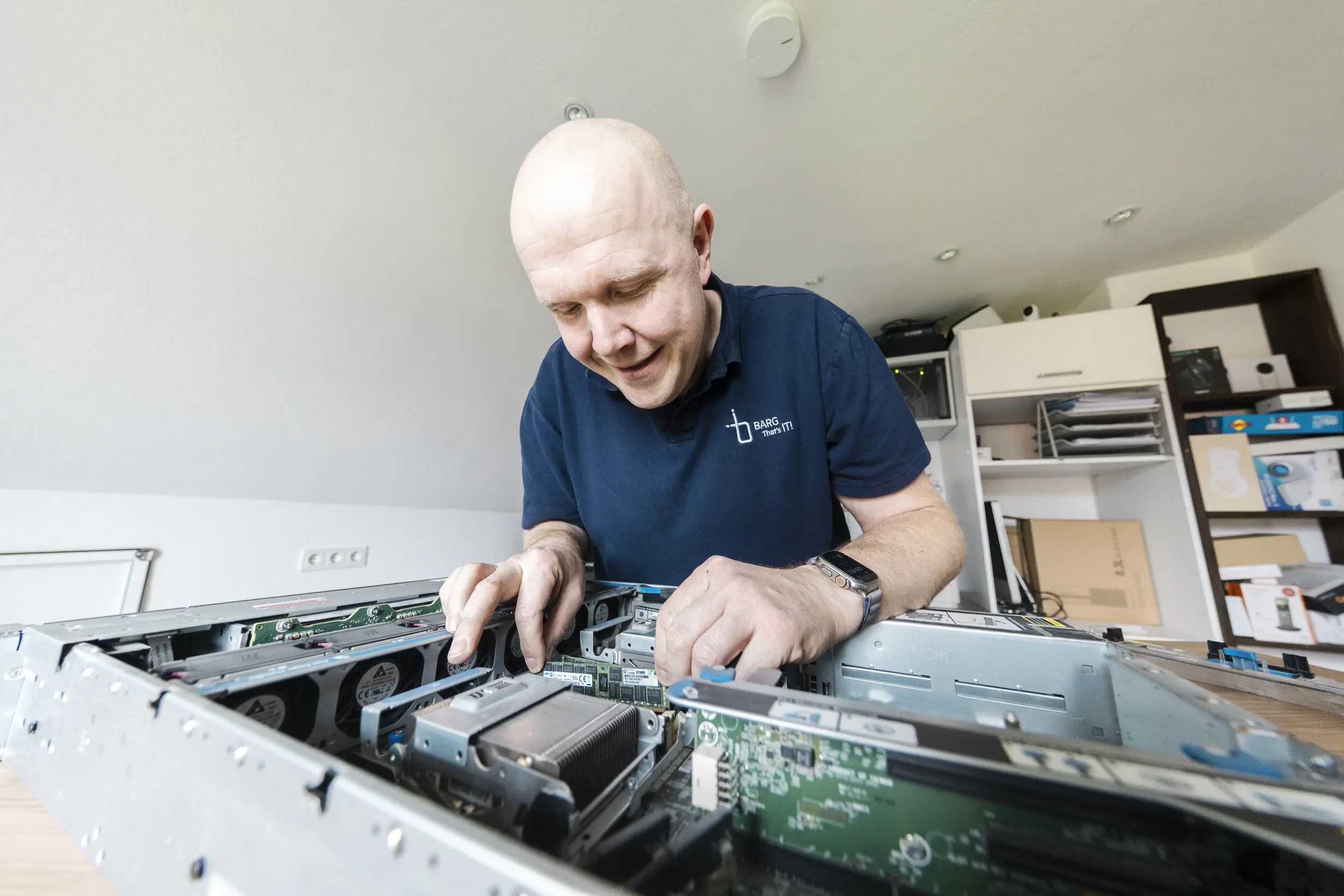 Mann öffnet Computergehäuse und arbeitet an Bauteilen im Inneren